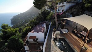 Eine luxuriöse Villa mit privatem Pool, Sitzgelegenheiten im Freien und einem herrlichen Meerblick.