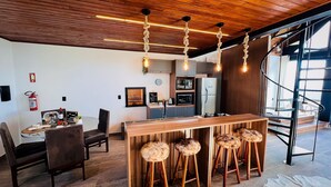 Uma cozinha moderna com armários de madeira, forno embutido e geladeira de aço inoxidável.