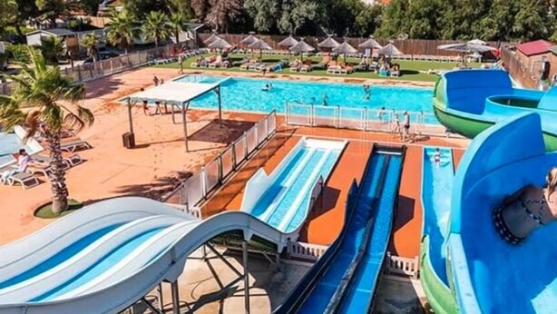 A water park with multiple slides and a swimming pool. - Mobilhome. (Torreilles)