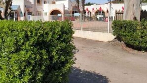 A pathway leading to a building with arched windows and a dome structure. - Mobilhome. (Torreilles)