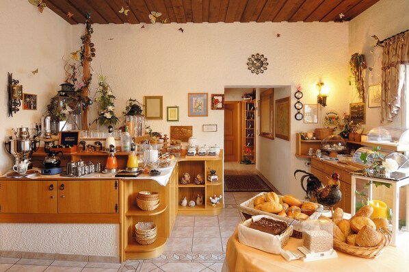 A breakfast buffet with various food items and a wooden counter. - Hotel Ursula (Bad Brueckenau)