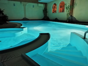 A swimming pool with a curved design and steps leading into it.