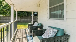 A covered porch with wicker furniture and a window.
