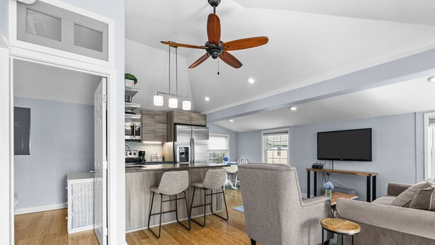 A spacious living area with a kitchen, a dining area, and a seating area with a sofa and chairs.