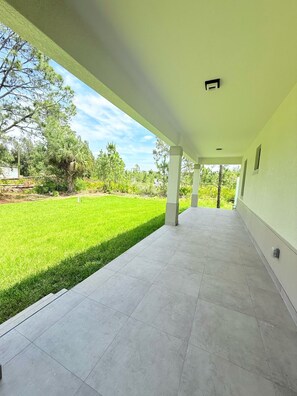 Relax in a serene outdoor space surrounded by lush greenery and a clean, minimalist design.