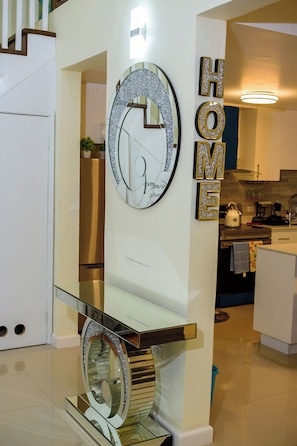 Una cocina moderna con una vitrina de vidrio, un espejo decorativo y un letrero que dice 'HOME'.