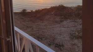 A sunset over a calm body of water with a view of distant mountains. - Beachfront Bliss in Portmore – Stylish 1BR with Ocean Views & Modern Comfort (Portmore)