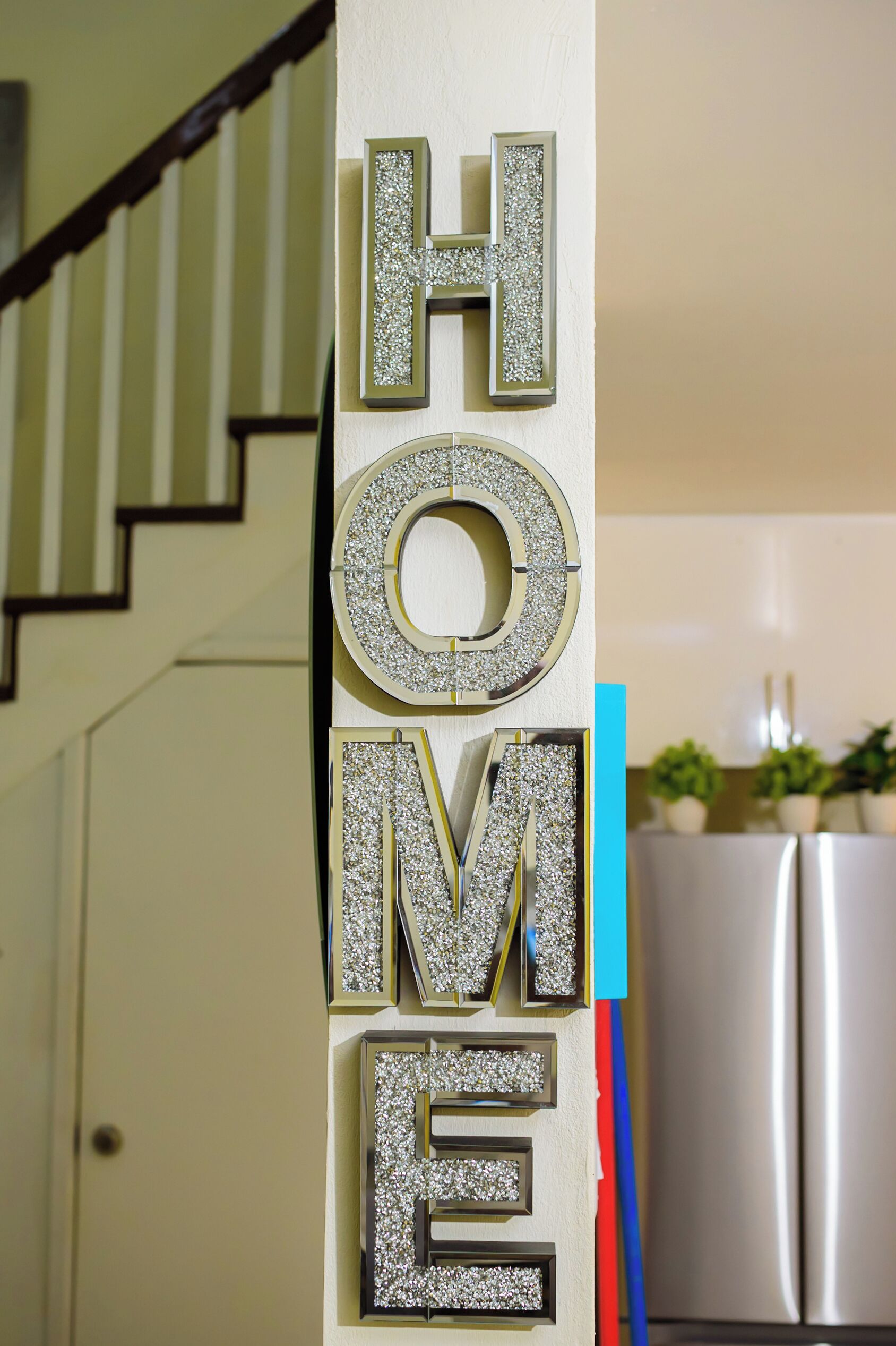 Een trap met een decoratief bord waarop 'HOME' staat.