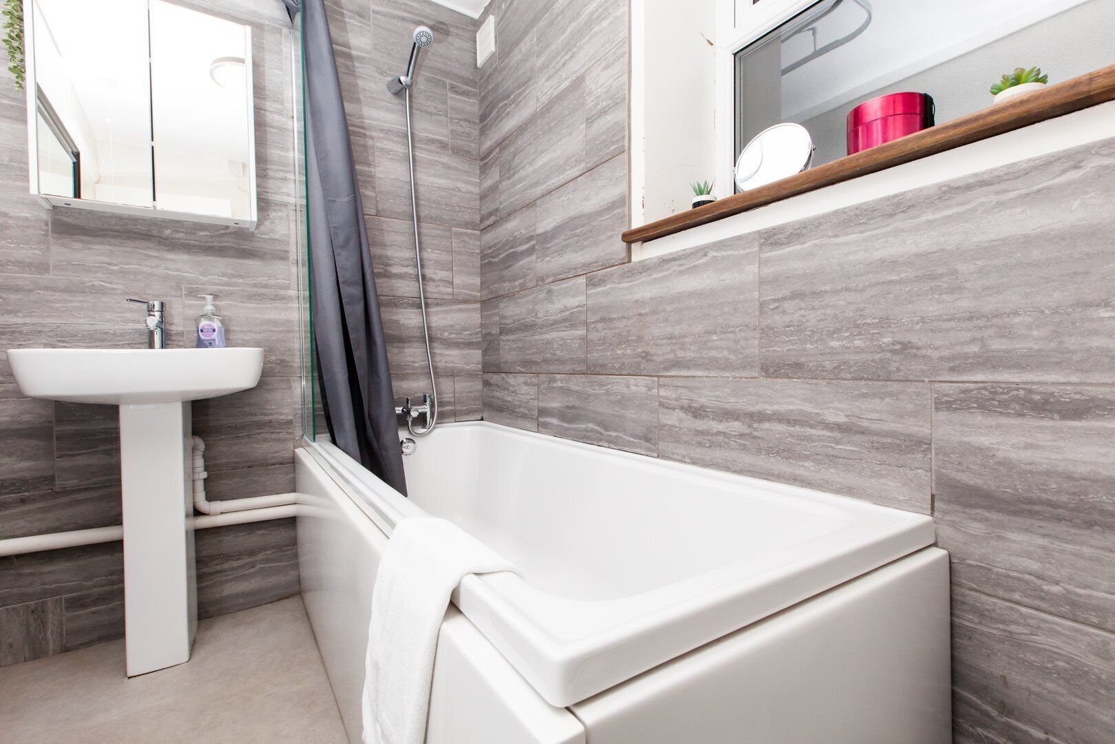 A modern bathroom with a bathtub, a sink, and a shower.