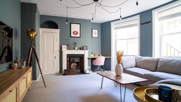 Un salon avec une cheminée, un canapé, une table basse en bois et une lampe.