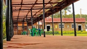 A covered outdoor area with a building in the background. - rwabs legacy motel mubende (Mubende)