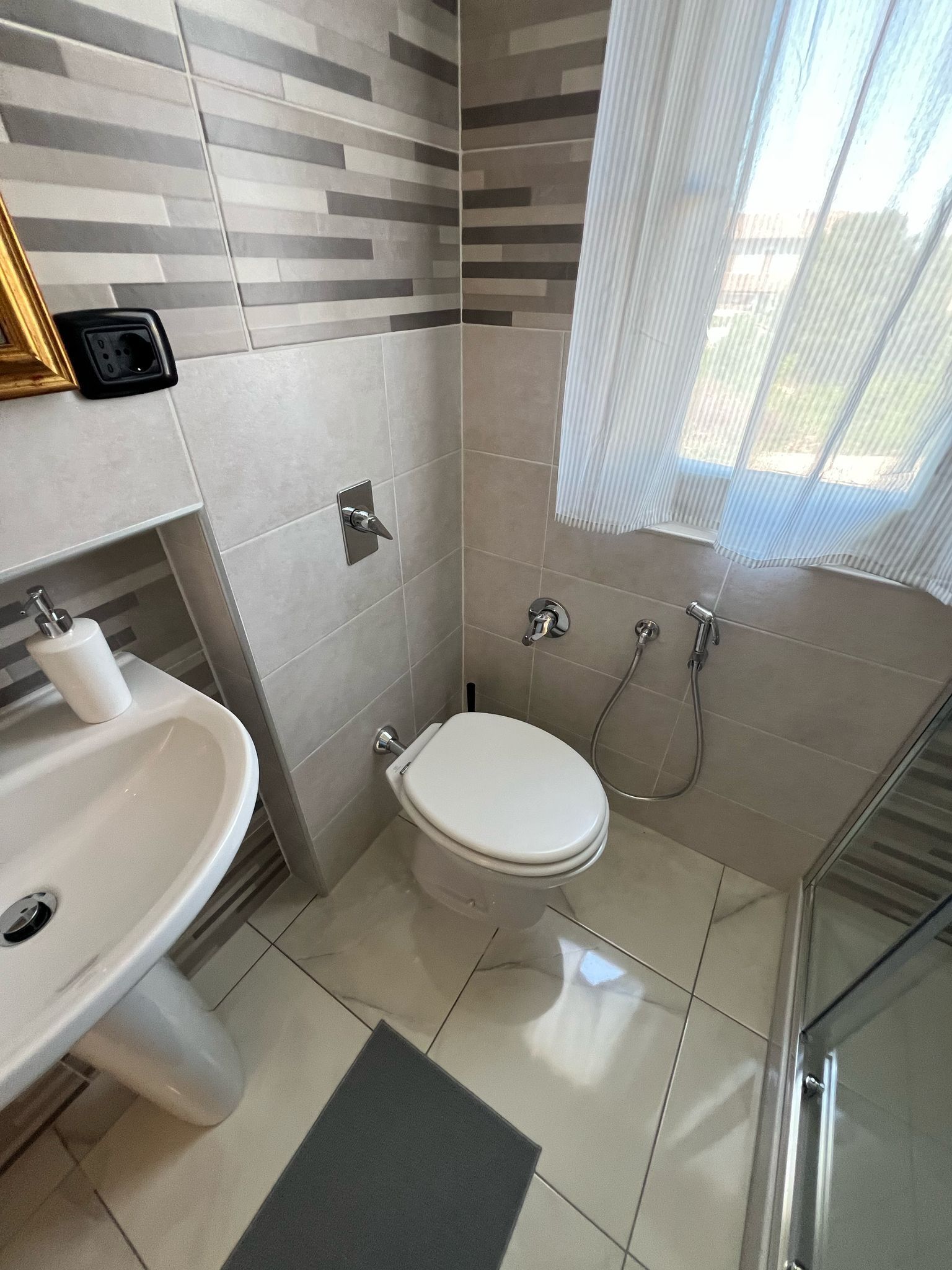 A bathroom with a toilet, sink, and shower.