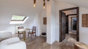 Une chambre de style loft moderne, dotée d’une lucarne, d’une table à manger en bois et offrant une vue sur l’extérieur.