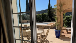 A patio with a pool, outdoor furniture, and a view of the surrounding landscape.