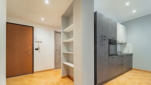 A modern kitchen with grey cabinets, a built-in oven, and a sink. - Dimora Bassignano - Two Bedroom Apartment, Sleeps 5 (Cuneo)