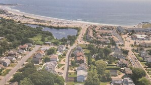 Vista aérea de una zona residencial costera con casas, una playa y una masa de agua.
