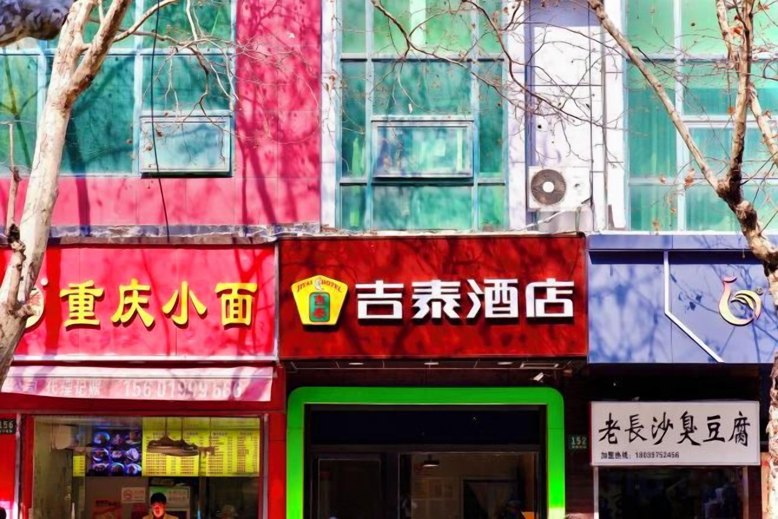 A row of storefronts with signage in Chinese characters, including one for a hotel.