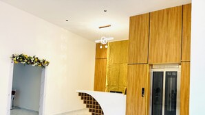 A modern reception area with a marble floor, wooden paneling, and a white reception desk. - Whiteridge Premium Hotel Hitech city (Hyderabad)