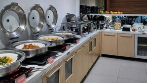 A buffet setup with various food items, including a section labeled 'Cereal & Bread.' - QUEEN CITY HOTEL (Banjarmasin)