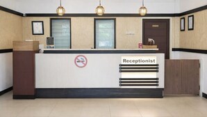 A reception desk with a 'Receptionist' sign, a no-smoking sign, and a door labeled 'Offices'. - QUEEN CITY HOTEL (Banjarmasin)