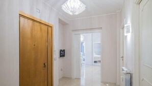 A hallway with a wooden door, a white door, and a radiator. - B&B Damagi (Rome)