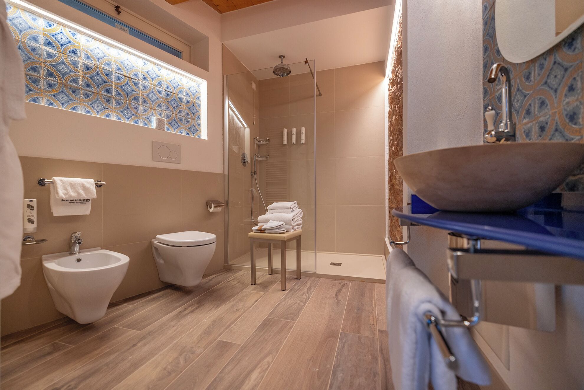 A modern bathroom with a bidet, toilet, and a glass-enclosed shower.