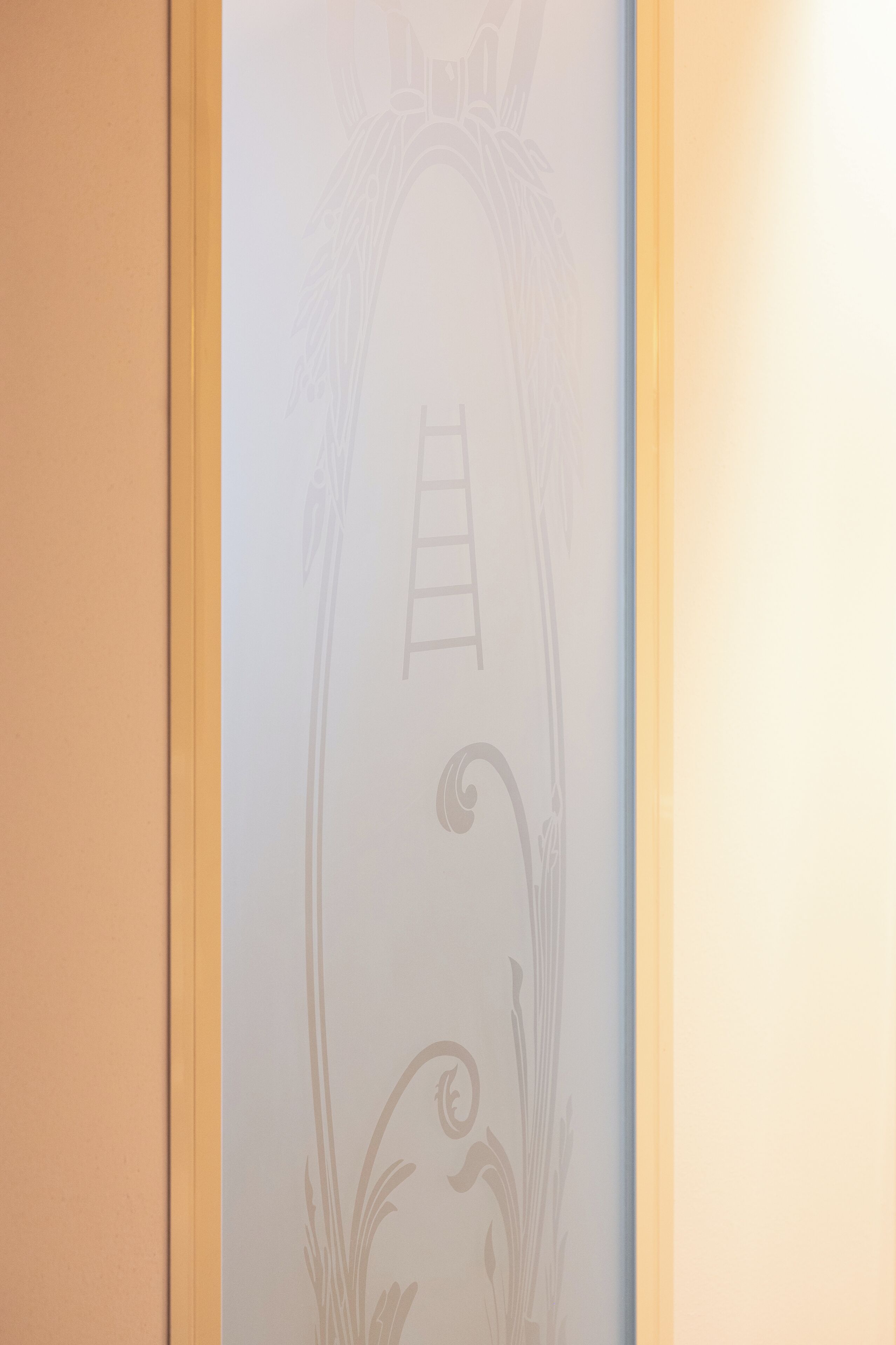A wall with a decorative design including a ladder and floral elements.