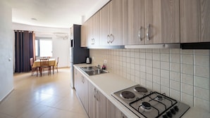 Una cocina moderna con armarios de madera, una estufa a gas y un comedor con mesa y sillas.
