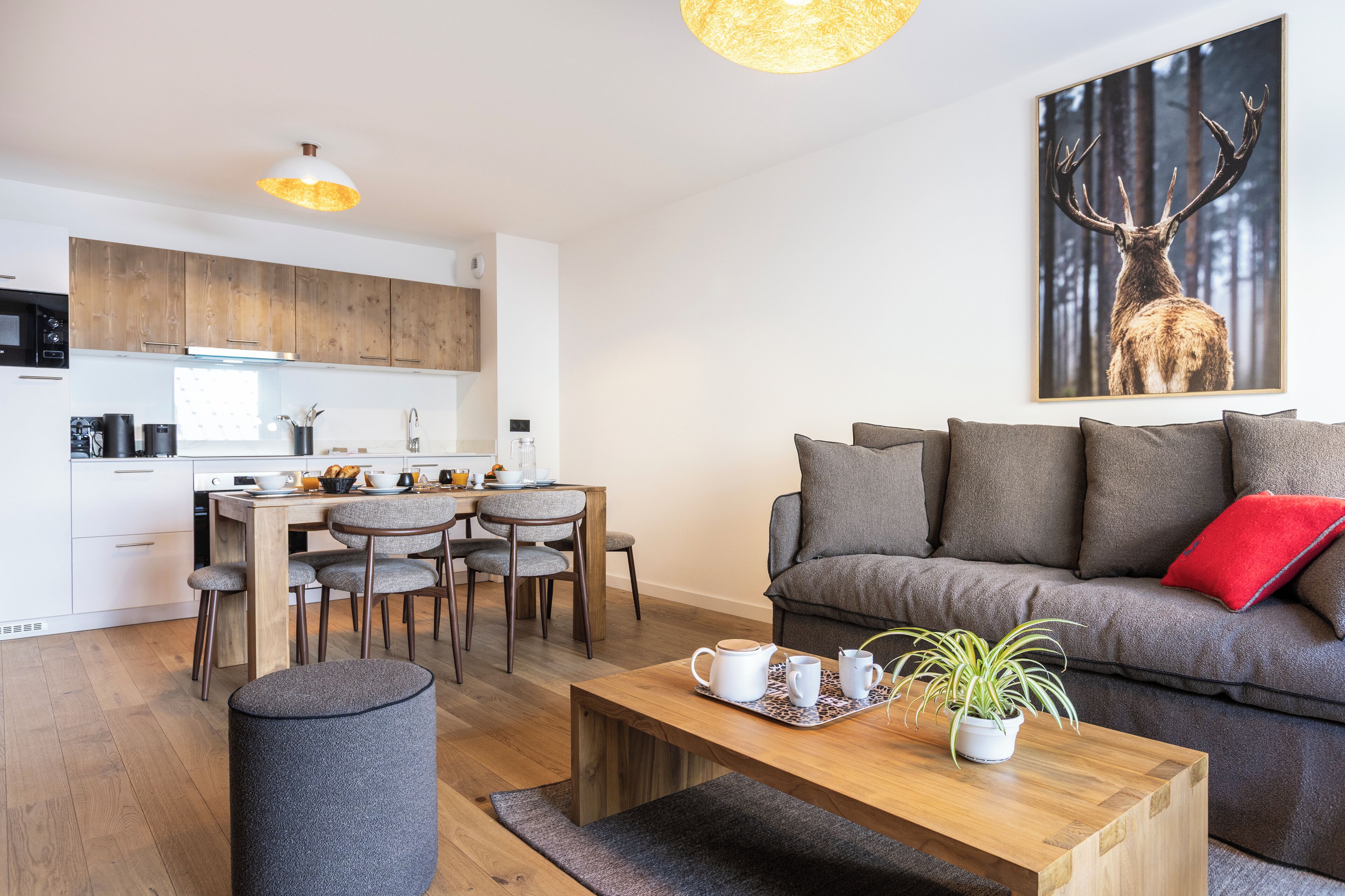 Een moderne woonkamer met een bank, salontafel en een eethoek met stoelen en een tafel.