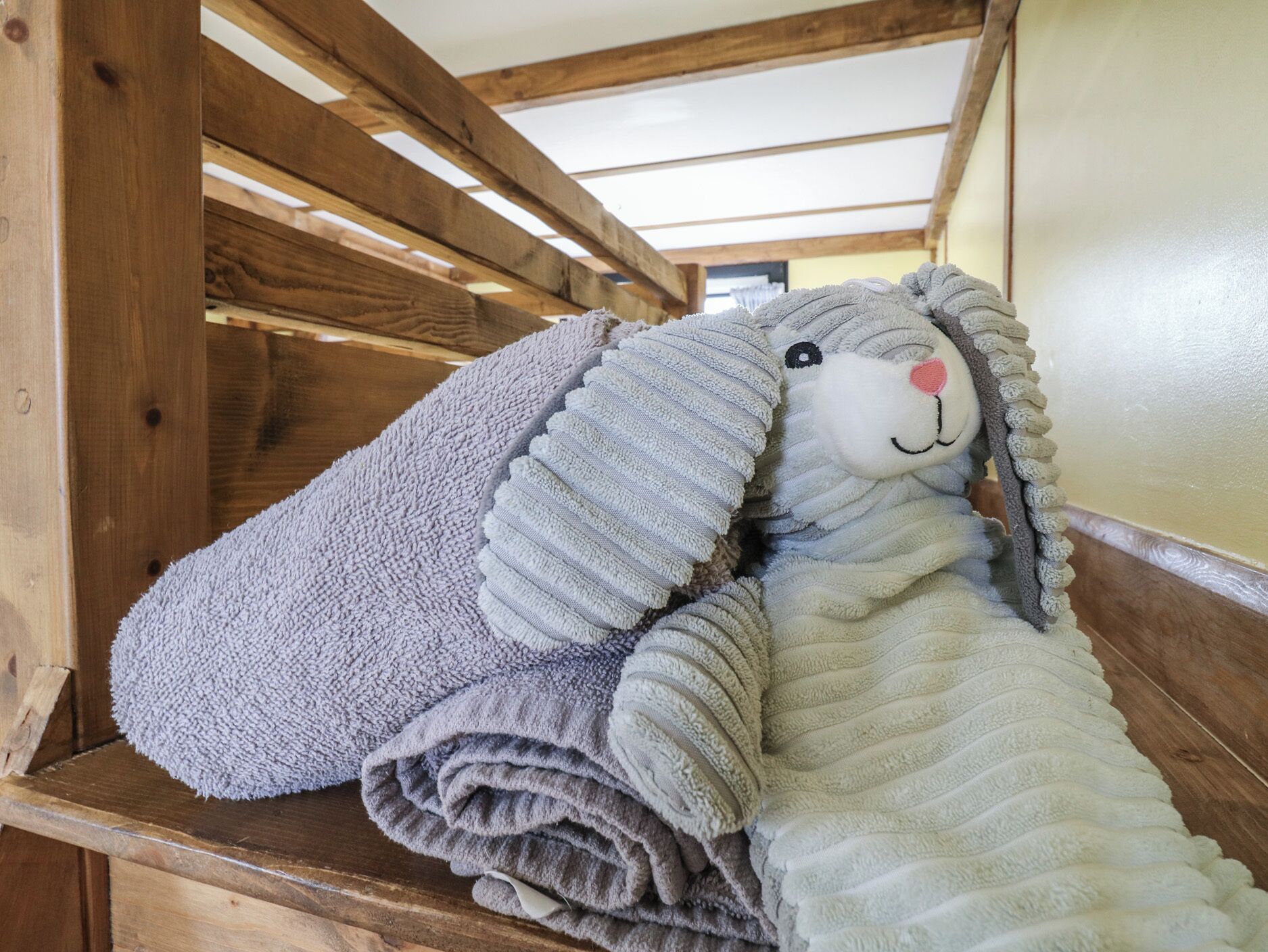 A wooden staircase with a plush toy resembling a sheep.