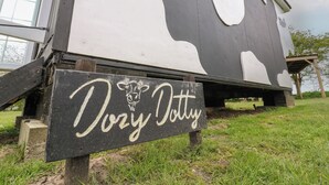 Ein schwarz-weißes Haus mit einem Schild, auf dem 'Dairy Dolly' steht.