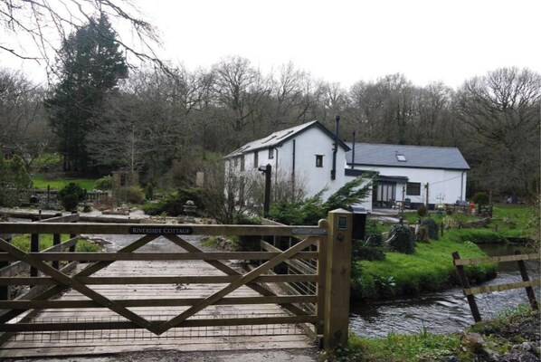 Riverside Cottage offers a serene natural setting with a tranquil body of water nearby.