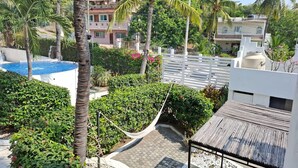 Ein Wohngebiet mit Swimmingpool, Palmen und einem weißen Zaun.