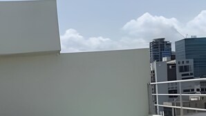 A rooftop terrace with a hot tub, wooden steps, and a view of surrounding buildings. - City Center Apartment Torre Leonardo VI (Santo Domingo)