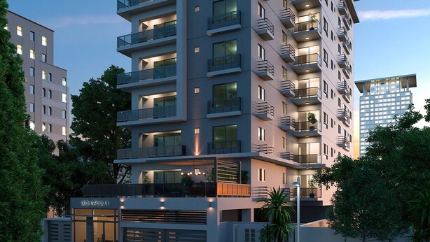 A multi-story residential building with balconies, a garage, and a street view. - City Center Apartment Torre Leonardo VI (Santo Domingo)