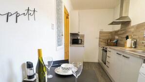 Una cocina moderna con comedor, que incluye microondas, horno y pileta.