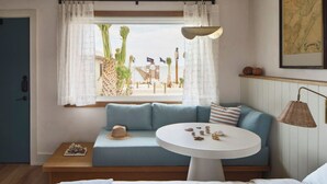 Ein Zimmer mit einem blauen Sofa, einem runden weißen Tisch und einem Bett.