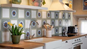 A kitchen with a tiled backsplash, a sink, a stove, and a range hood. - Green Lodge - Apartment 5 - 1 BR 1 Bath (Cressa)
