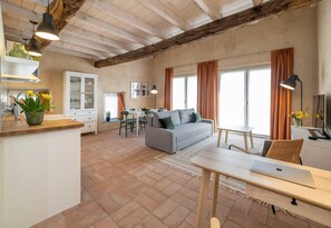 Un espacio habitable amplio con sofá, mesa de comedor y zona de cocina.