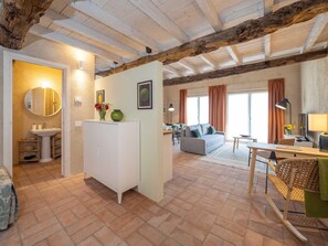 A cozy living area with a sofa, a dining table, and a kitchen area with a sink and cabinets.