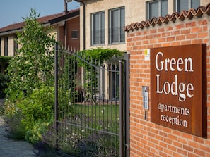 A brick building with a sign reading "Green Lodge apartments reception". - Green Lodge - Apartment 2 - Studio (Cressa)