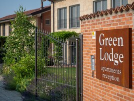 Un edificio de ladrillo con un letrero que dice 'Green Lodge apartments reception'.