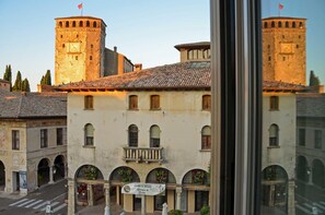 A historic building with a central courtyard, arched windows, and a tower with a clock. - Palazzo Benassi Penthouse (Asolo)