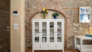 Ein weißer Schrank mit Glastüren, eine Steinwand und eine Tür mit Griff.