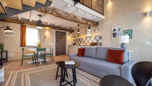 A cozy living room with a sofa, chairs, a coffee table, and a dining area with a table and chairs.