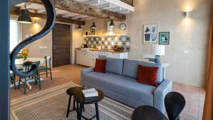 A modern living room with a grey sofa, red cushions, a coffee table, and a dining area with a table and chairs.