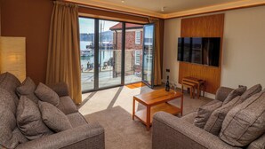 Een moderne woonkamer met een groot raam, een flatscreen televisie en een houten salontafel.