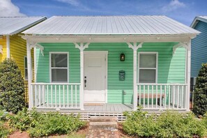 A green house with a white porch and a white door. - Historic Bungalow w/ Hot Tub, Walk to St. George (St. Augustine)