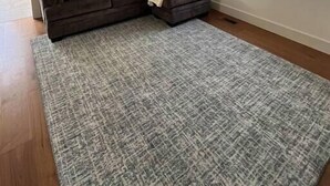 A living room with a sectional sofa, ottoman, and patterned rug. - The Royal Union w/ king & queen bed (Calumet Township)