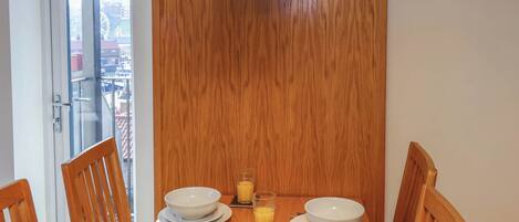 A dining table with a breakfast setting including croissants, raspberries, and orange juice.